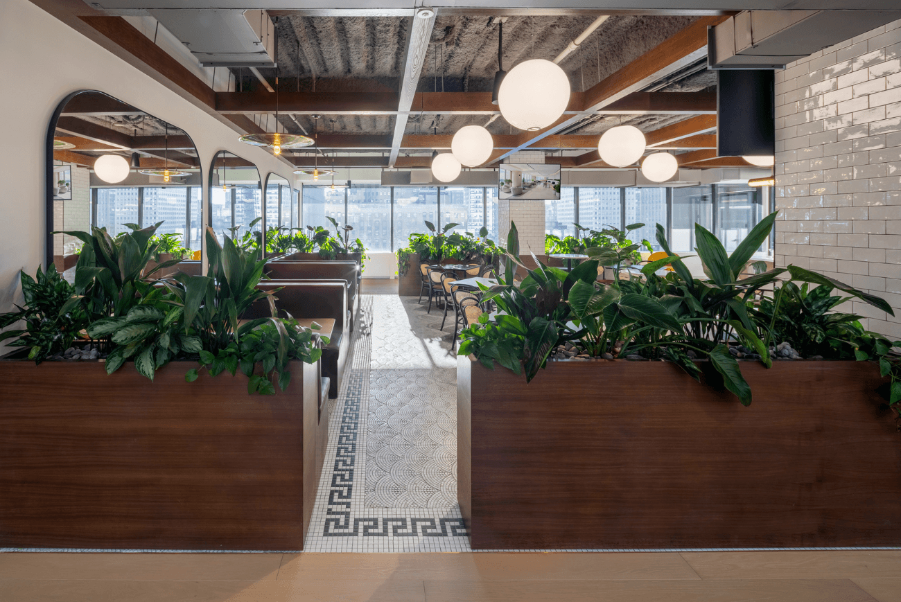 Café space with custom millwork planters wrapping seating areas above the Manhattan skyline, by Greenery NYC